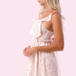 Adult woven pink tie back ruffle smocked mini dress featuring a flattering smocked bodice and playful ruffles, perfect for summer outings and special occasions.